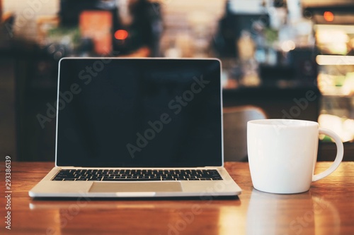 laptop and cup of coffee on wooden table