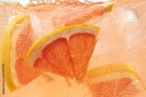 Fotografia Close up view of the lemon and grapefruit slices in lemonade background