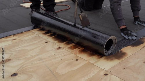 Bitumen roofing.,  with a gas burner and a roll of tar paper. Flat roof installation.