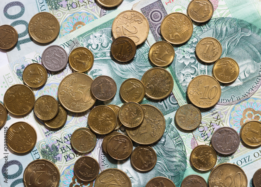 Flat lay of mixed coins isolated on white background. Mix of euro cents and Polish coins grosz lying on Polish 100 zloty banknotes. Background for business, banking or commerce. Flat lay of mixed coins isolated on white background. Mix of euro cents and Polish coins grosz lying on Polish 100 zloty banknotes. Background for business, banking or commerce.