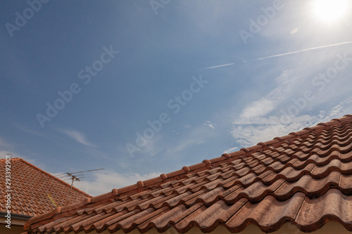 roof top on sky background. Close up of brown clay roof tiles. Red old dirty roof. Old roof tiles. Construction equipment build a house.