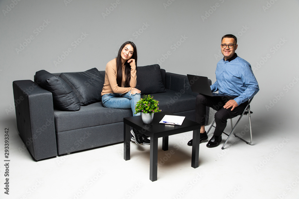 At the psychologist. Beautiful young woman is lying on couch and talking while doctor is making notes on laptop, At the psychologist. Beautiful young woman is lying on couch and talking while doctor is making notes on laptop,