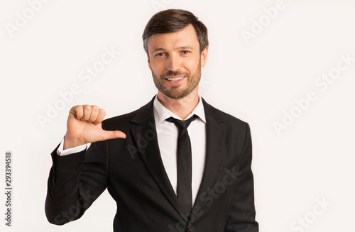 Business Guy Pointing Thumbs At Himself, White Background, Studio Shot
