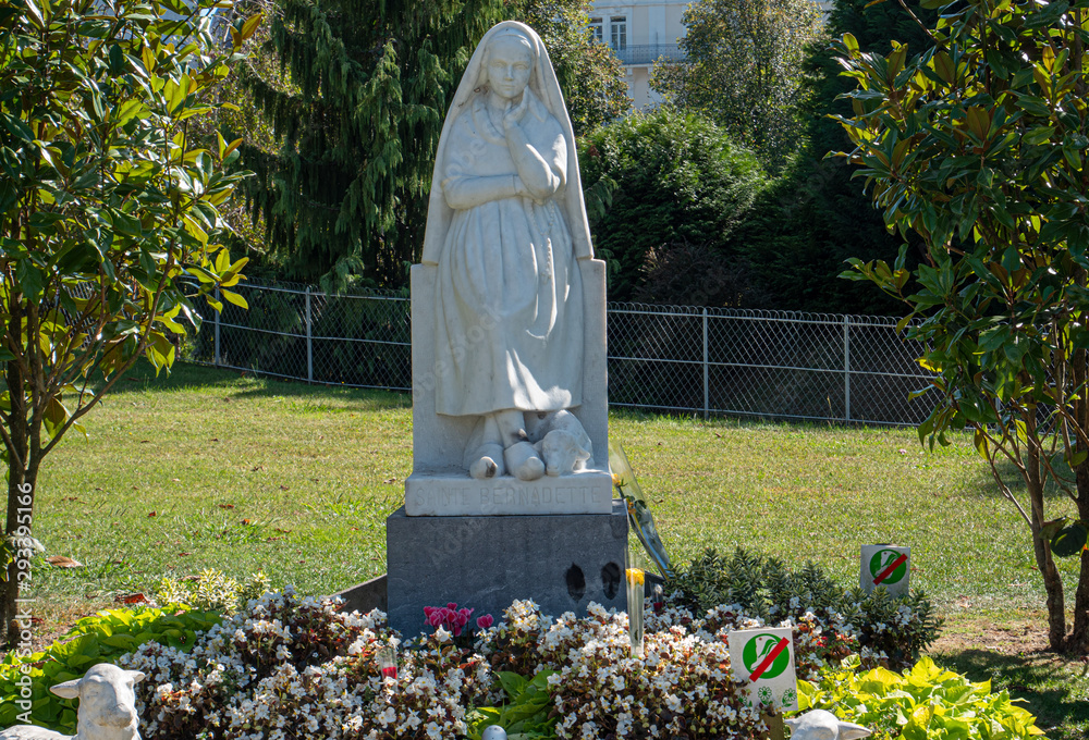 Fototapeta premium Statue of Bernadette of Lourdes with flowers