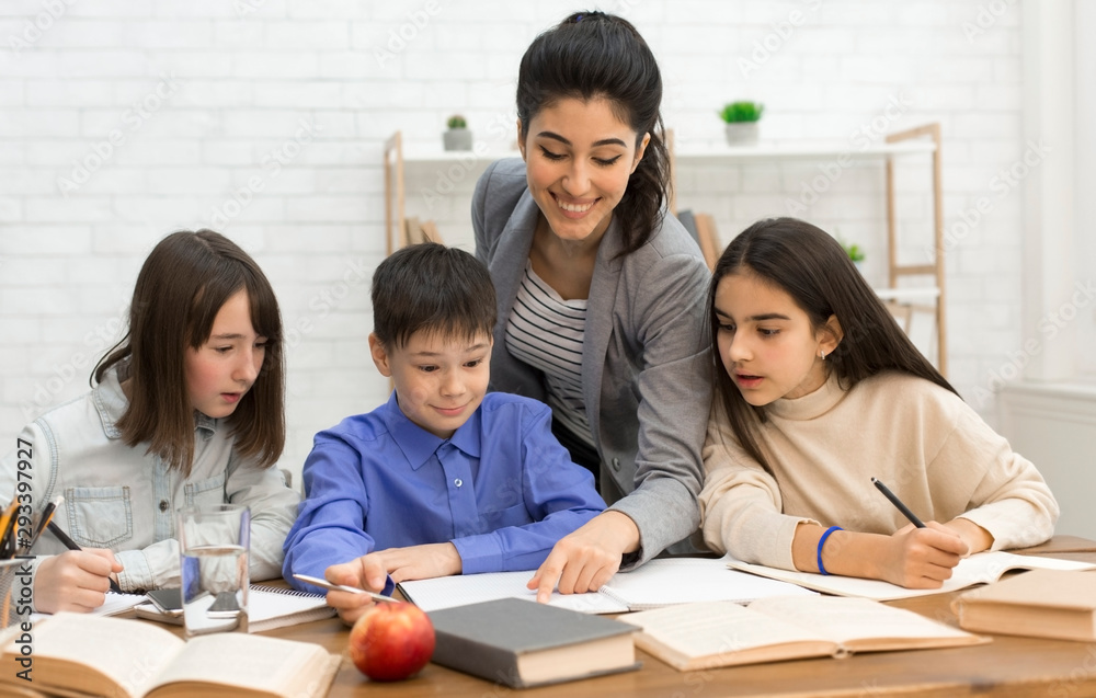 Education concept. Happy teacher helping children doing test Education concept. Happy teacher helping children doing test