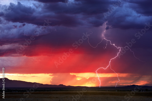 Thunderstorm with lightning bolt strikes at sunset