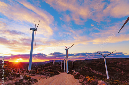 Wind turbines spinning at sunset