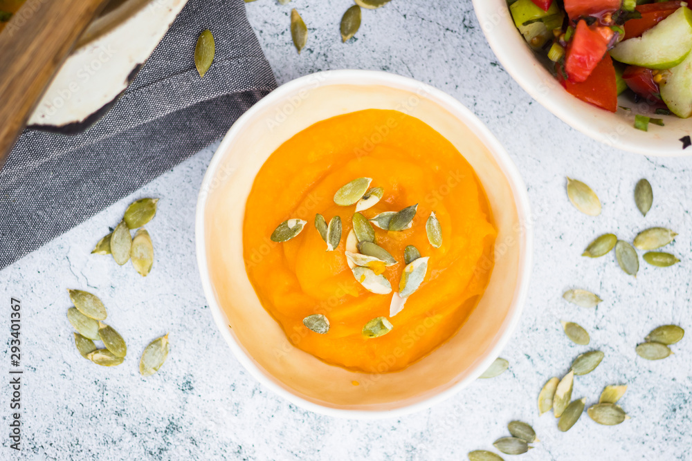 Cooked yellow pumpkin puree with pumpkin seeds in bowl. Vegan, vegetarian. Creamy. Cooked yellow pumpkin puree with pumpkin seeds in bowl. Vegan, vegetarian. Creamy.