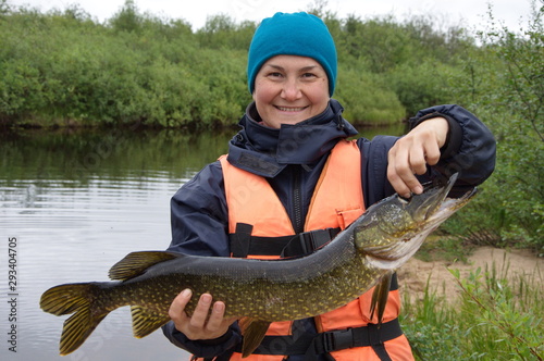 Woman caught a pike in the northern river.