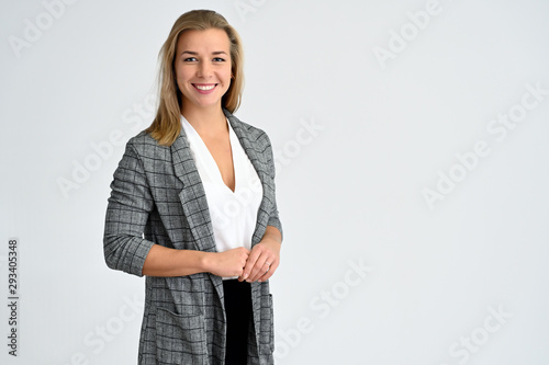 Close-up portrait of a cute caucasian blonde female student girl in a gray jacket on a white background. Wide smile, happiness. It is in different poses.