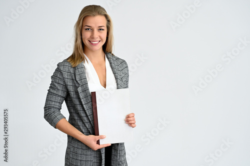 Close-up portrait of a cute caucasian blonde female student girl in a gray jacket on a white background. Wide smile, happiness. It is in different poses. photo