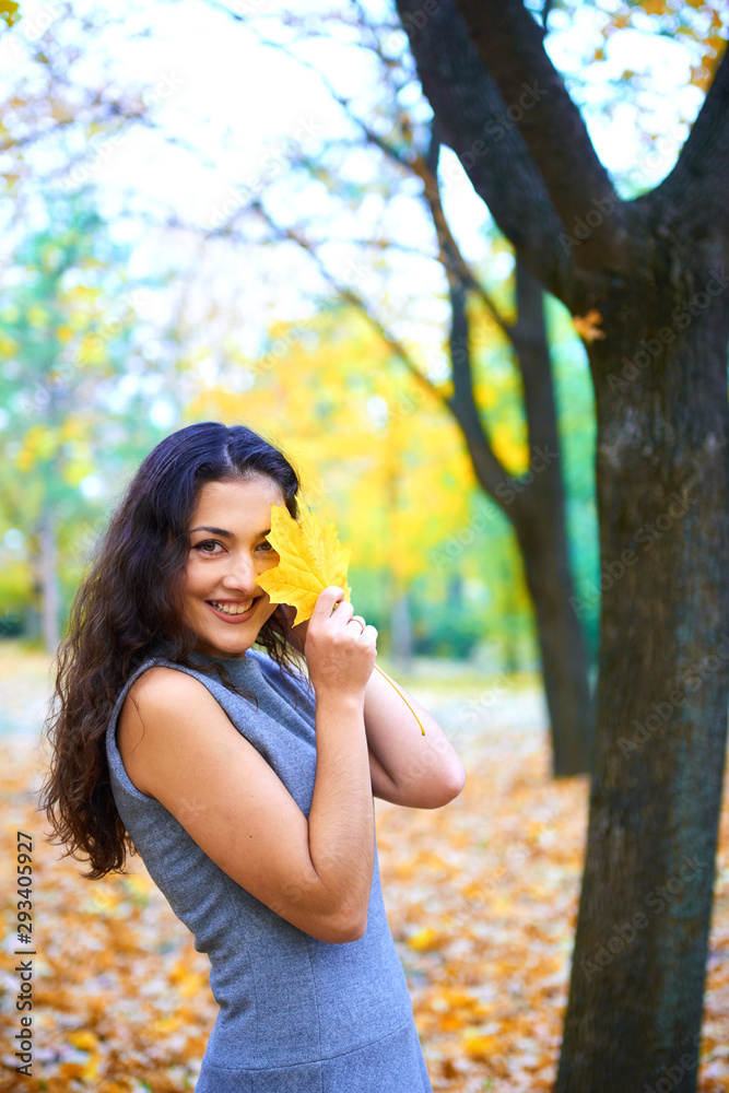 woman posing with autumn leaves in city park, outdoor portrait woman posing with autumn leaves in city park, outdoor portrait