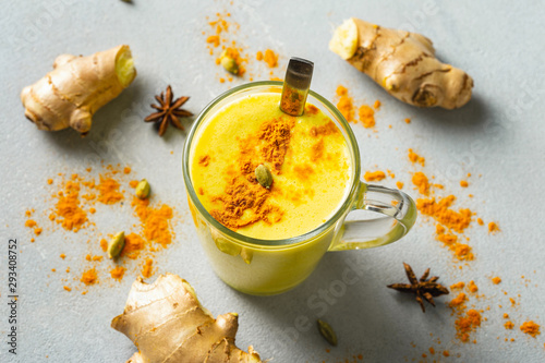 Golden latte on light background. Indian drink turmeric golden milk in glass