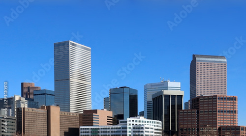 Urban cityscape and modern architecture background. Denver downtown buildings and skyscrapers in morning sunlight against blue sky, Colorado, USA.