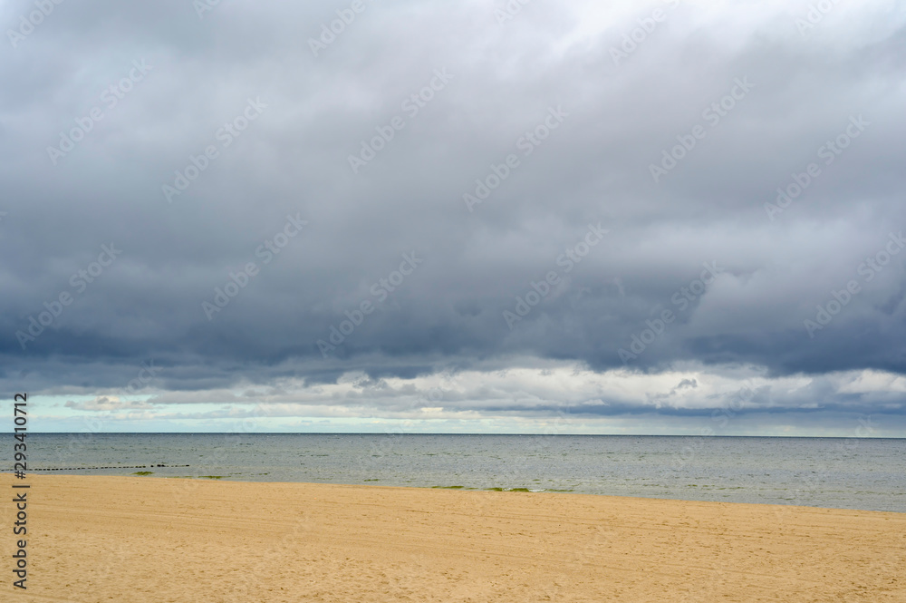 Lonely beach on Usedom with view over the sea to dramatic looking storm clouds.
