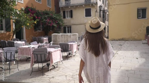 Traveler young beautiful woman walking exploring old european town Kerkyra, Corfu island, Greece.