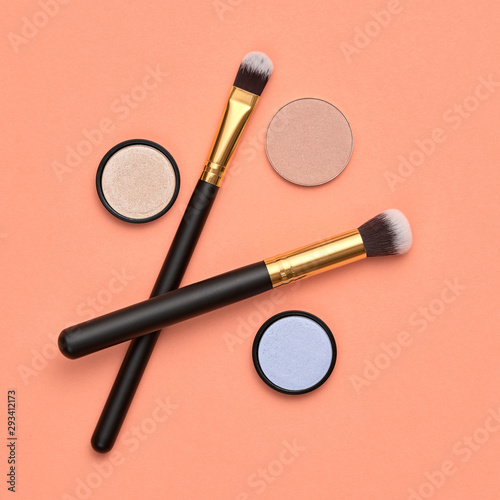 Fashion cosmetic makeup autumn Set. Minimal. Beauty product on coral background. Trendy accessories Brushes Eyeshadow art fashionable Flat lay. Creative make up fall autumnal concept