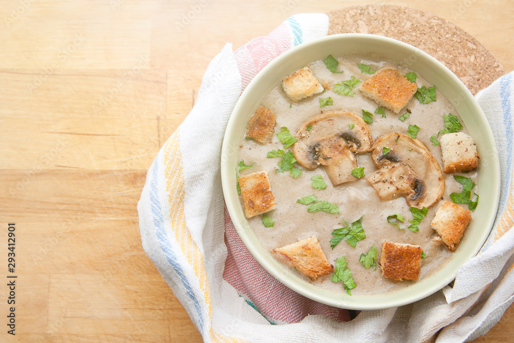 Cream of champignons soup with parsley and croutons, on a wooden background. Hot dish. Top view, food. Cream of champignons soup with parsley and croutons, on a wooden background. Hot dish. Top view, food.
