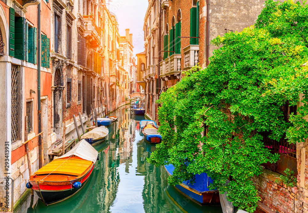 Narrow canal with boat and bridge in Venice, Italy. Architecture and landmark of Venice. Cozy cityscape of Venice.