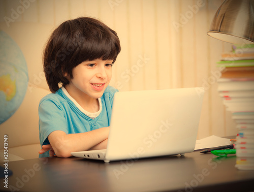 smiling boy looking at a computer monitor