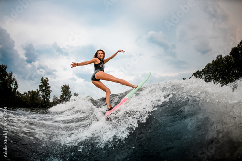 Female wakesurfer does stunts on a board