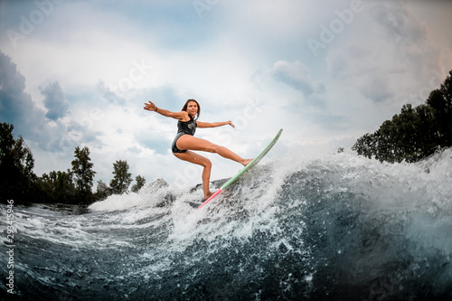 Female wakesurfer doing stunts on a board