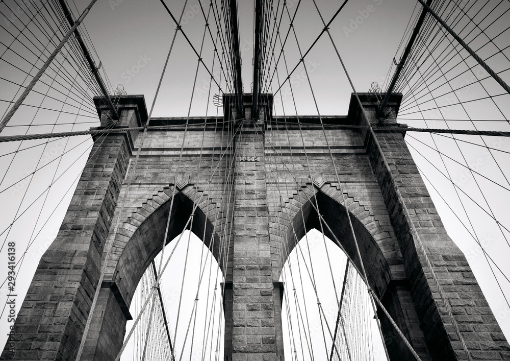 Fototapeta premium Brooklyn Bridge's tower with Gothic-style pointed arches and suspension cables, New York City, Manhattan, USA