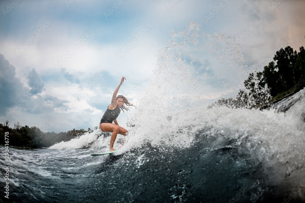 Girl wakesurfer slides smoothly on a board