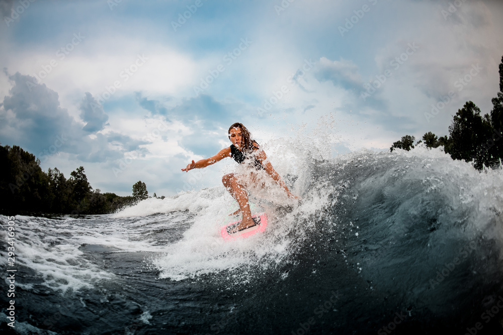 Girl wakesurfer sliding smoothly on a board