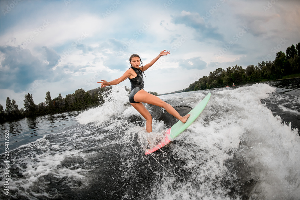 Girl wakesurfer posing on a surf board