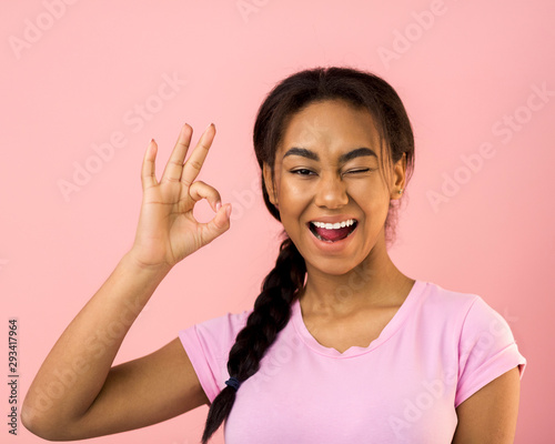 It's OK. Happy girl gesturing OK sign and winking