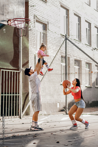 sports family plays basketball, mom, dad and daughter