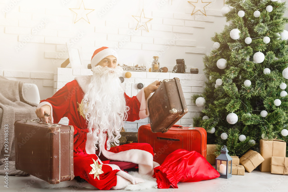 Obraz premium Christmas Santa Claus with suitcases at his home. Christmas, New Year.