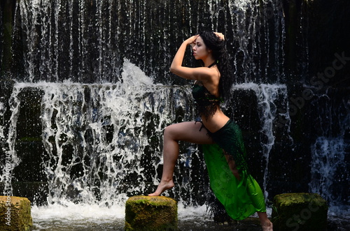 Fotografi Young brunette model posing against a waterfall