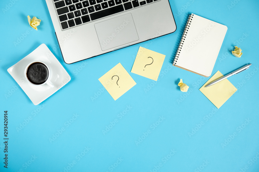 Question mark on sticky notes, notebook, cup coffee, laptop and pen on blue background. FAQ concept. Working with clients. Troubles in work. Flat lay, top view, copy space Question mark on sticky notes, notebook, cup coffee, laptop and pen on blue background. FAQ concept. Working with clients. Troubles in work. Flat lay, top view, copy space