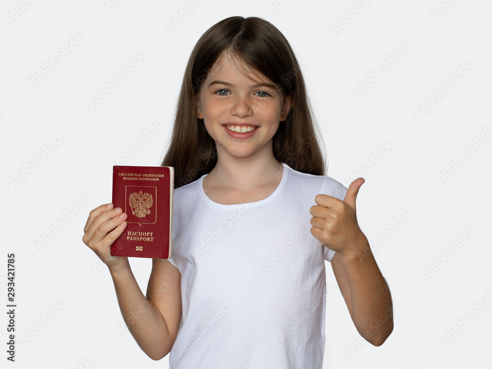 russian smiling little girl holding a foreign passport and showed a thumbs up