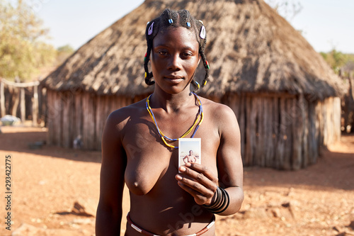 Mudimba tribe woman showing a picture of herself, Canhimei, Angola.