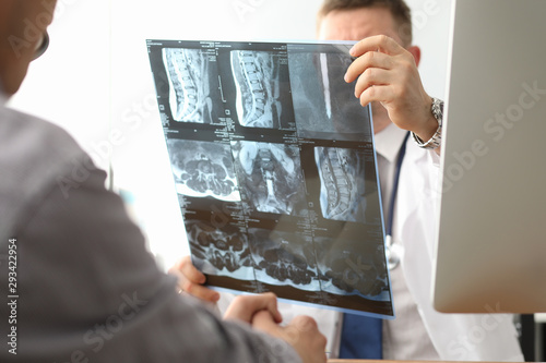 Doctor hold xray bone spine radiography in hand. Examination and treatment of intervertebral hernia. Traumatology tomography hospital radiographer concept. photo