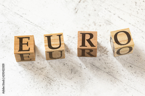 Four wooden cubes with word EURO on white working board photo