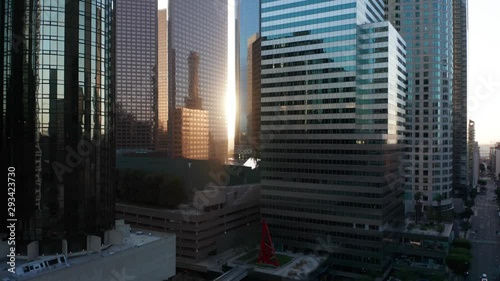 Slowly rising up together with the sun next to tall skyscrapers in the financial district downtown Los Angeles, cinematic shot, perfect for motivation, development and industrial videos.