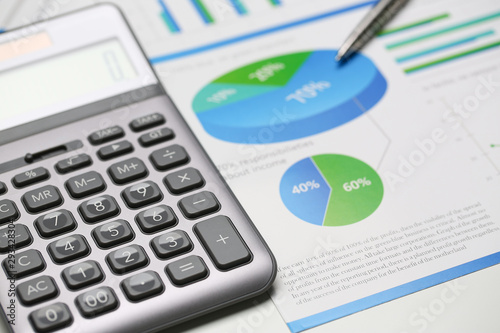 Silver calculator and financial statistics on clipboard pad at office table closeup. Internal Revenue Service inspector sum check irs investigation earnings savings loan and credit concept