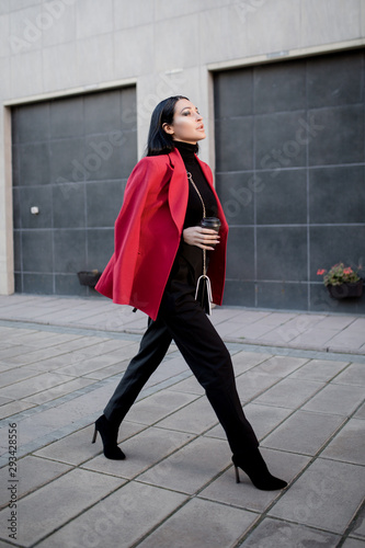 Wallpaper Mural Fashion woman in a red coat walks around the city. a cup of coffee Torontodigital.ca
