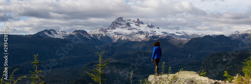 Adventurous Girl near a cliff enjoying the Beautiful Canadian Nature during a colorful and vibrant evening in Fall. Taken on a trail to Watersprite Lake near Squamish, North of Vancouver, BC, Canada. photo