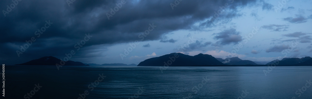 Beautiful Panoramic View of American Mountain Landscape on the Ocean Coast during a cloudy and rainy sunrise in fall season. Taken in Glacier Bay National Park and Preserve, Alaska, USA.