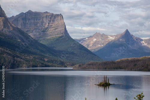 Beautiful View of a Glacier Lake with American Rocky Mountain Landscape in the background during a Cloudy Summer Morning. Taken in Glacier National Park, Montana, United States. © edb3_16