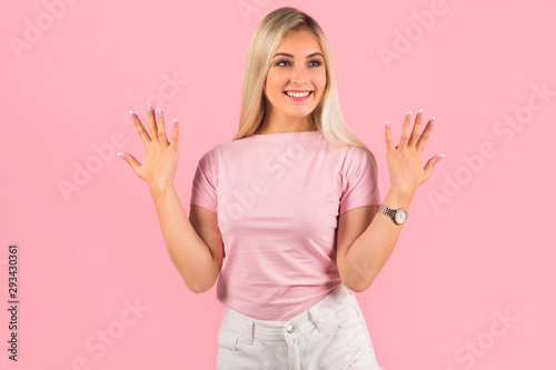 beautiful young woman on pink background with hand gesture