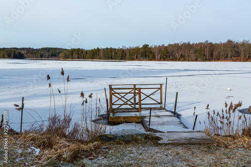 Jetty at a frozen lake with snow photo