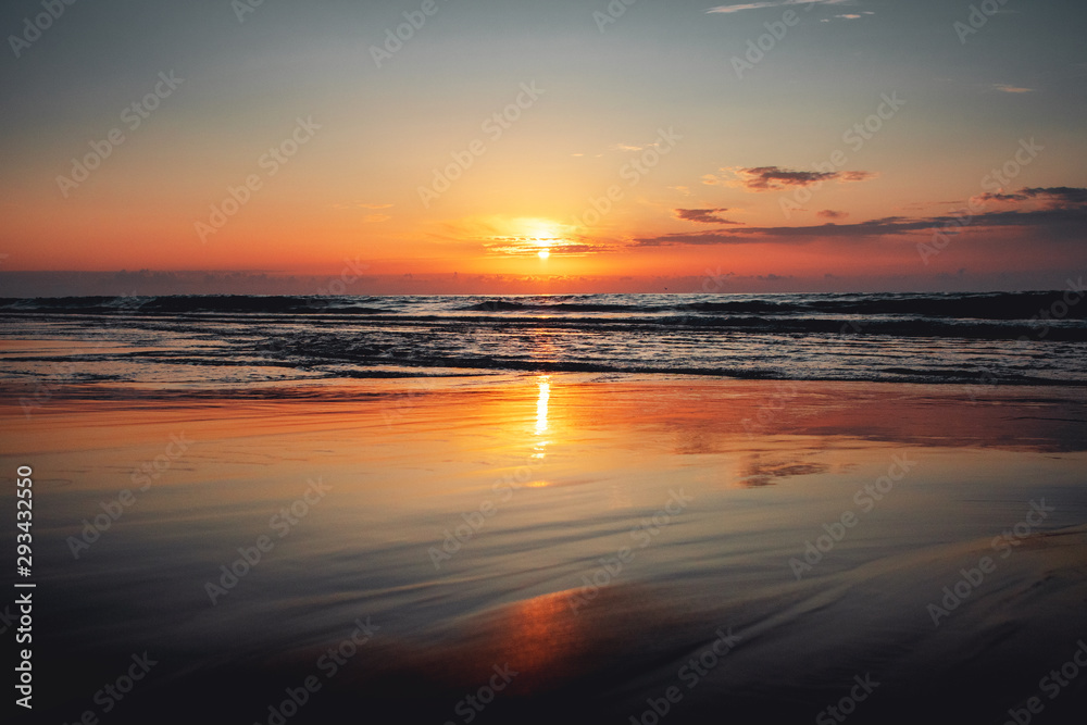 Beautiful sunset ocean view with waves and reflection. Praia da Bordeira at the Algarve Coast in Portugal, Atlantic Ocean