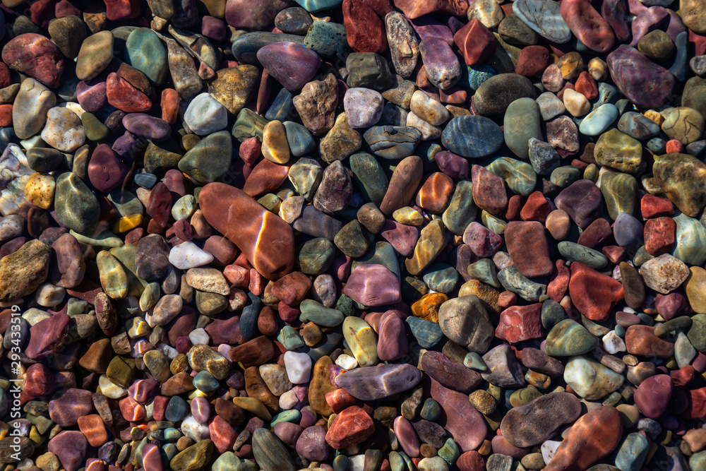 Colorful Rocks in a Glacier Lake during a sunny summer day. Taken in Lake McDonald, Glacier National Park, Montana, USA. Colorful Rocks in a Glacier Lake during a sunny summer day. Taken in Lake McDonald, Glacier National Park, Montana, USA.