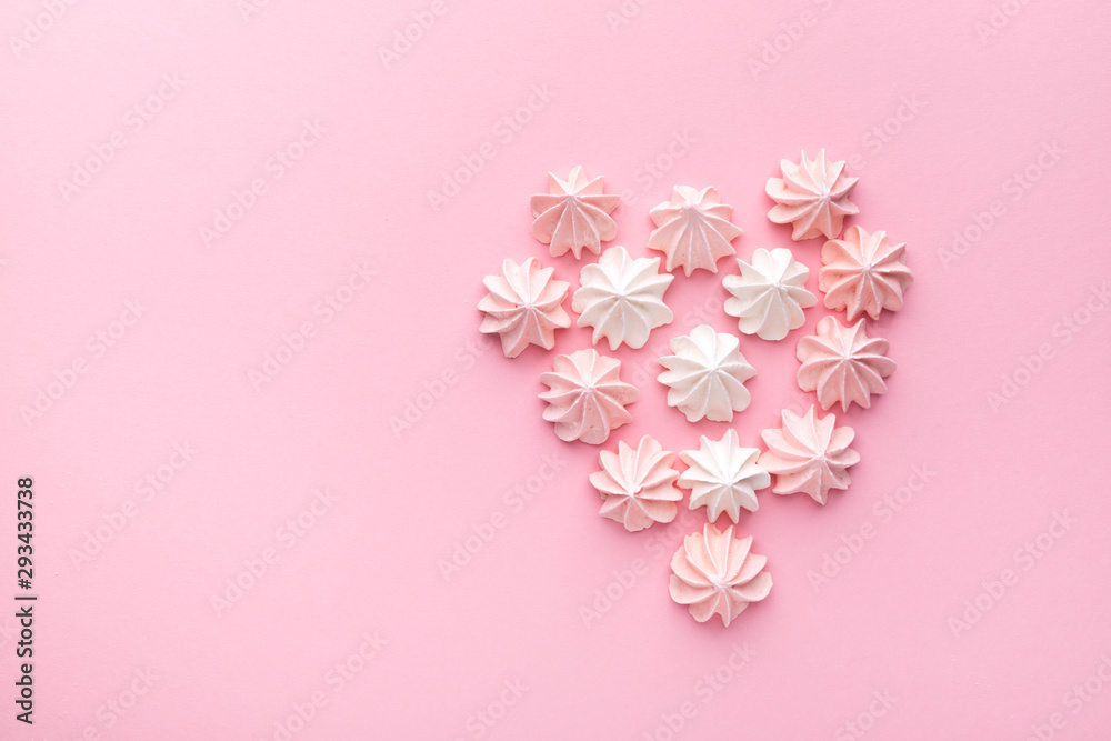 Valentine's day concept. Heart made of pink and white Bizet on a pink background. Top wiev